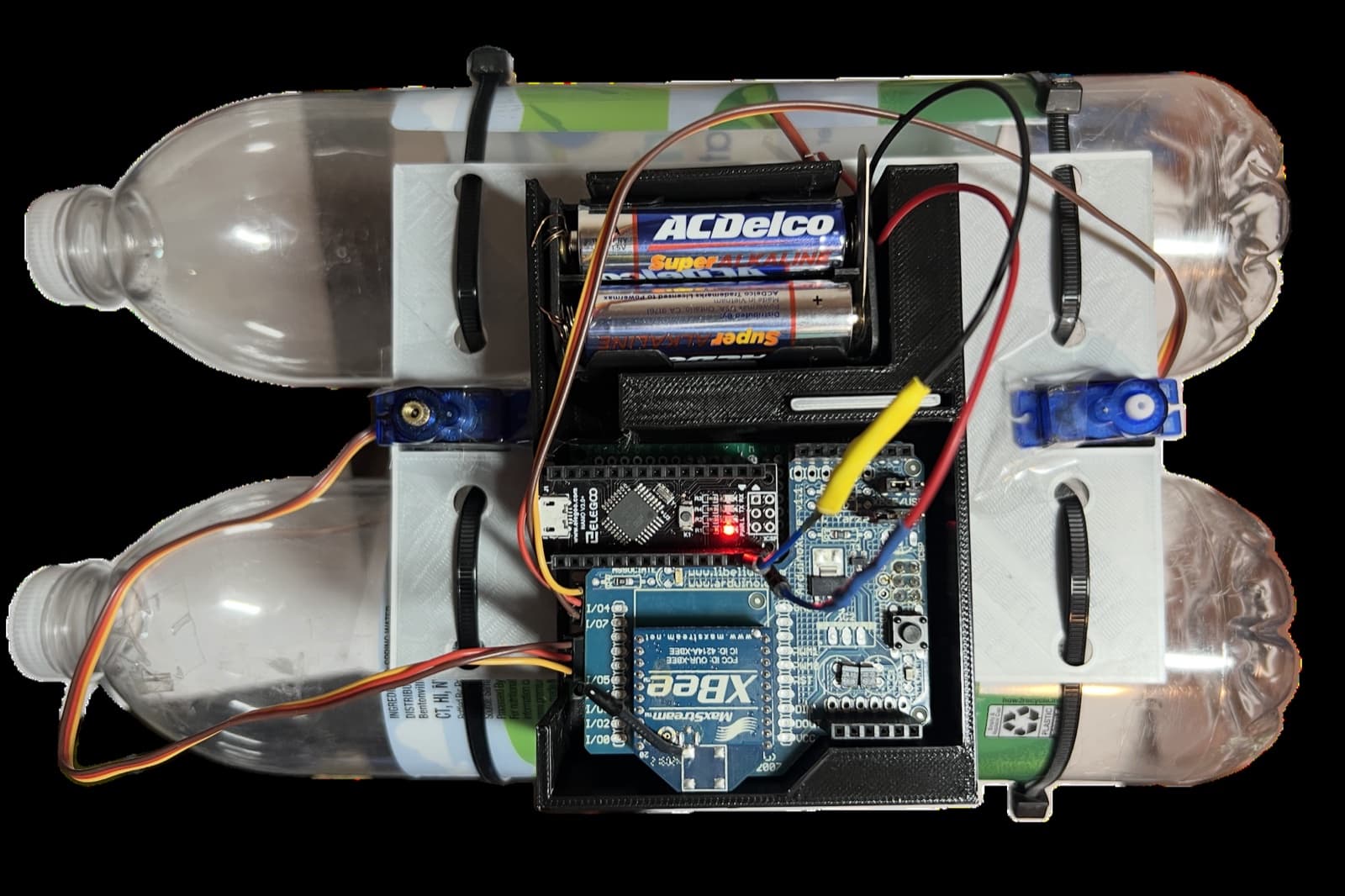 Top view of the sailboat with electronics exposed between two water bottles